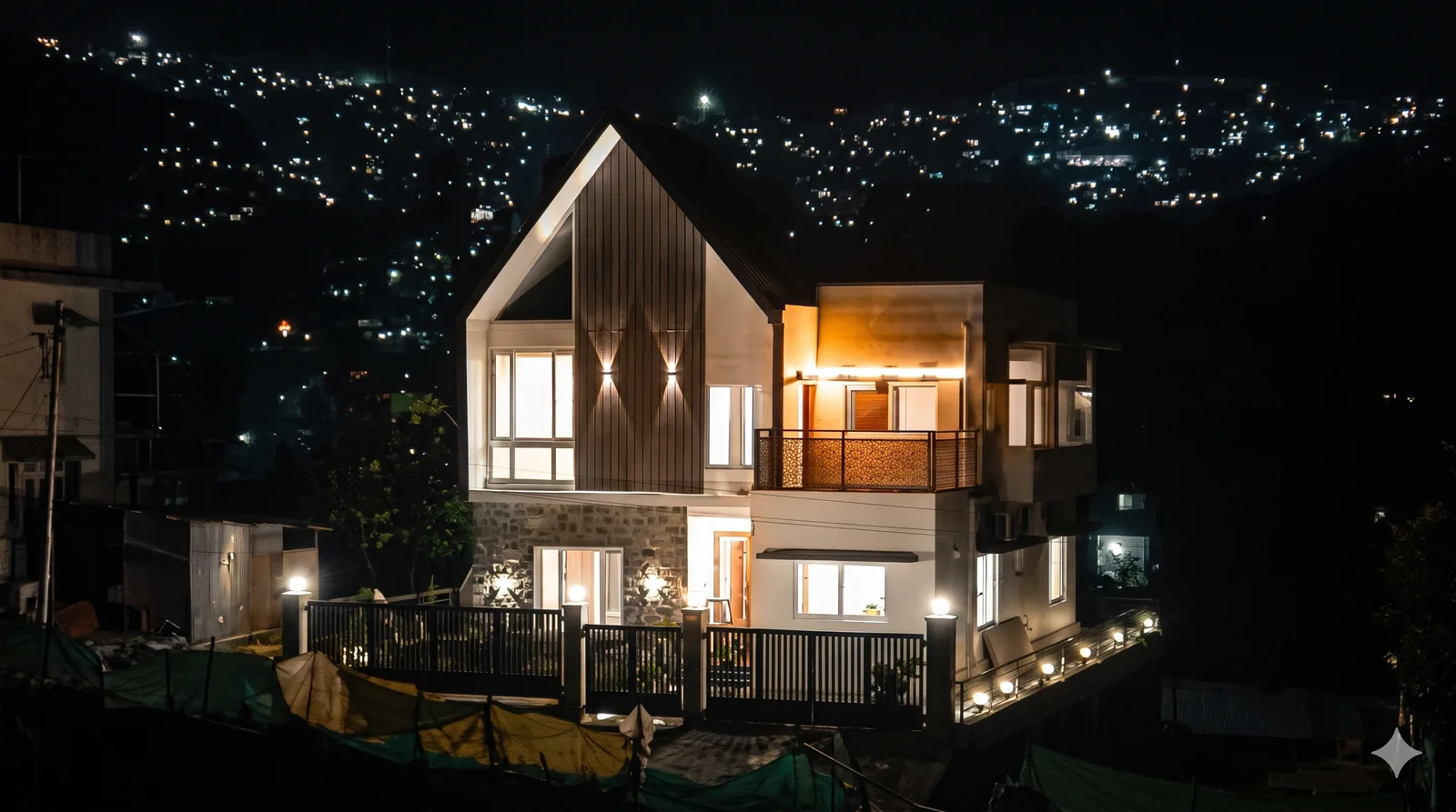Kalpana Villa in Kodaikanal, lit up at night with a hill view